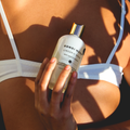 Person holding a bottle of Bondi Wash Lingerie Wash against a sunlit background