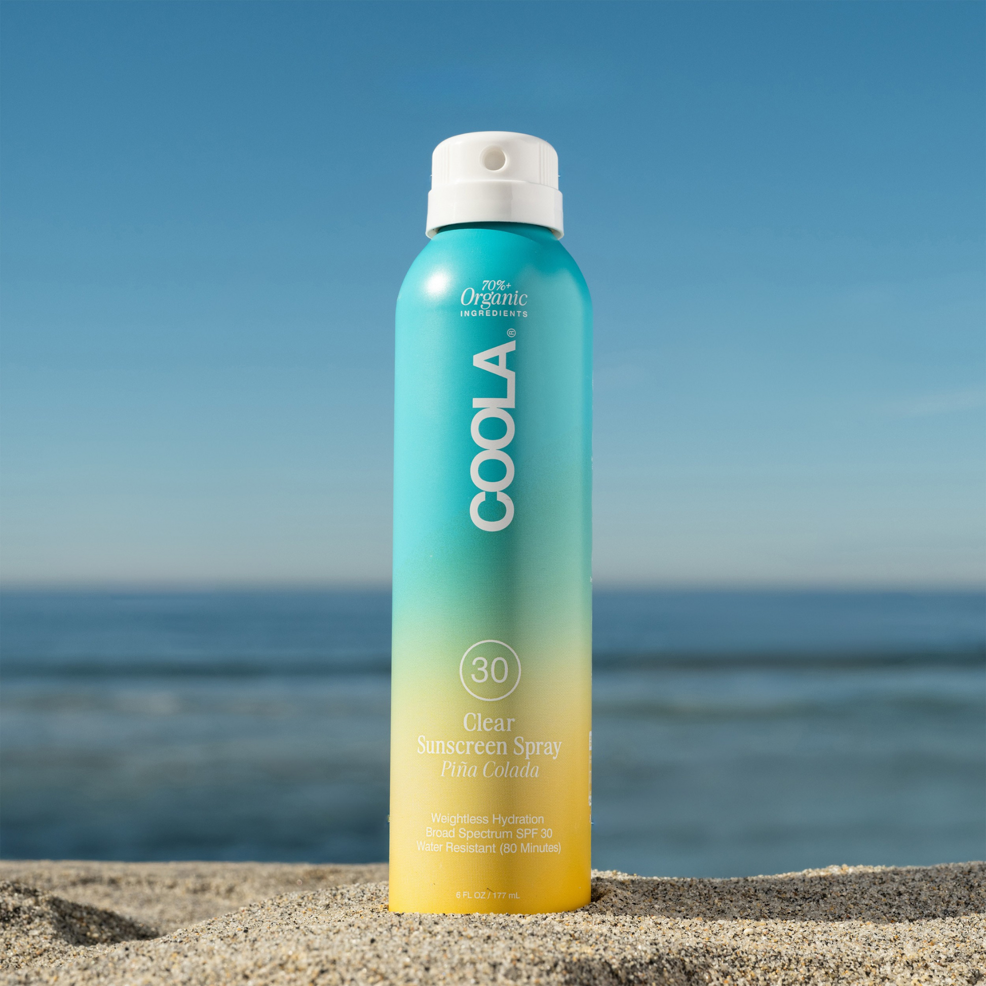 Coola Classic Body Organic Sunscreen Spray SPF30 with Pina Colada scent, featuring a spray bottle and tropical-themed label.