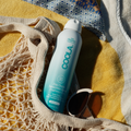Coola Zinc Oxide Sunscreen Spray SPF30, fragrance-free, in a white spray bottle with a blue cap, suitable for face and body.