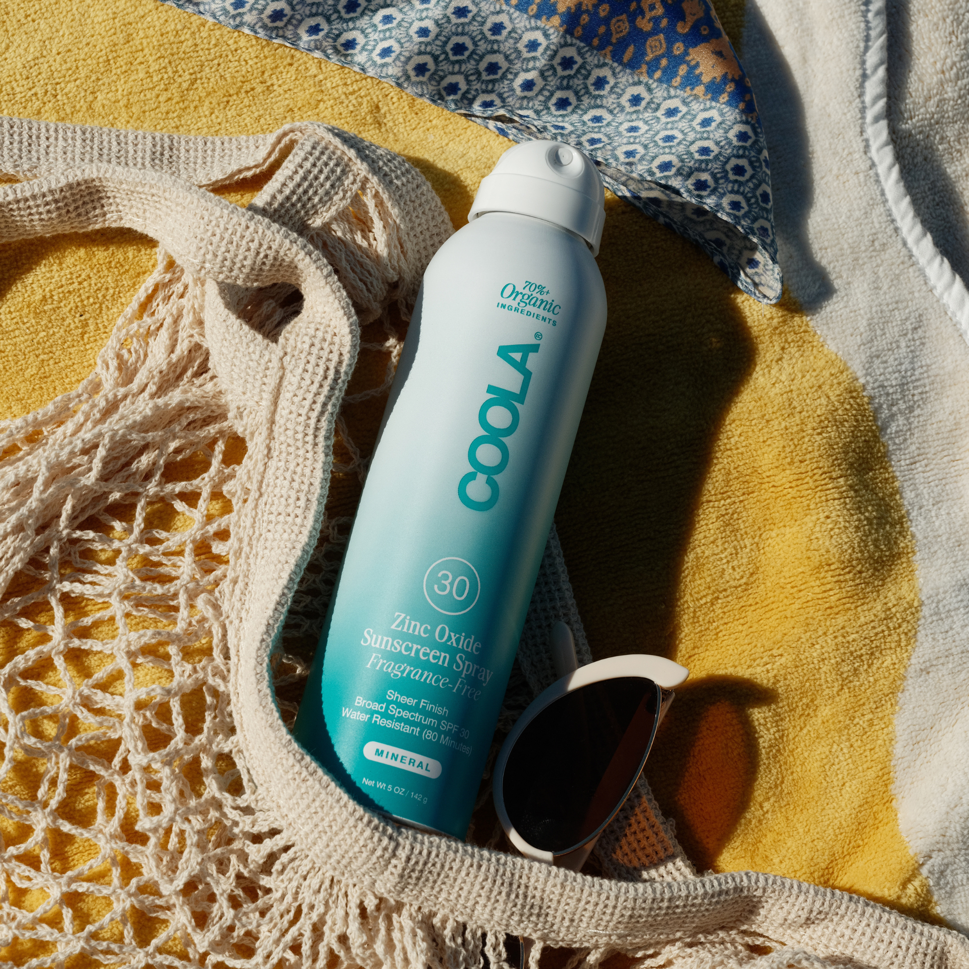 Coola Zinc Oxide Sunscreen Spray SPF30, fragrance-free, in a white spray bottle with a blue cap, suitable for face and body.