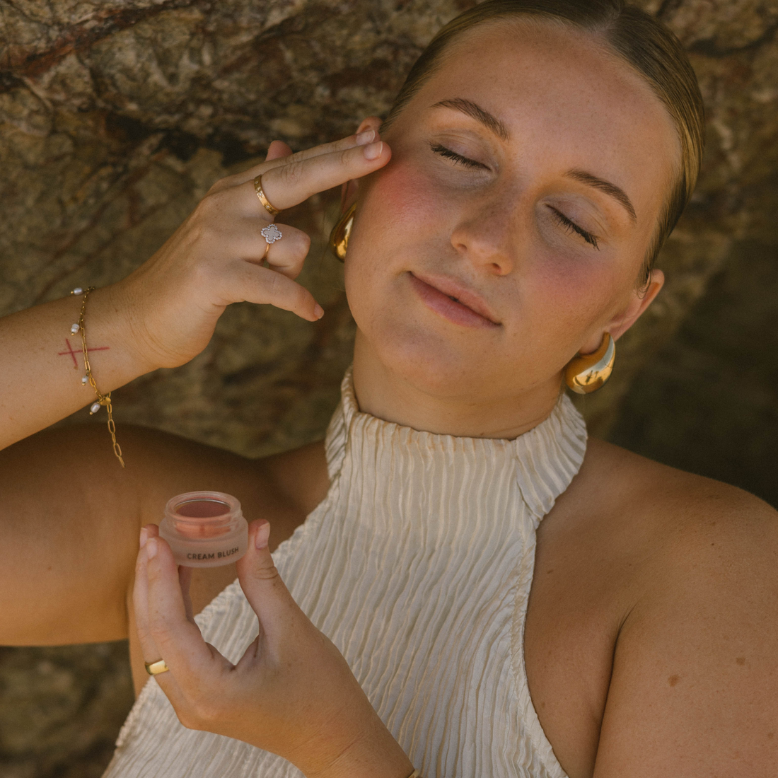 Eco by Sonya Driver cream blush in a soft, natural shade, displayed in a sleek compact with smooth, blended makeup application.