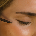 Close-up of a person applying Eco by Sonya Rich Brown eyeliner.