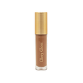A tube of Eco by Sonya Glory Gloss liquid makeup in a warm medium brown shade called Maple 08, featuring a textured metallic gold cap and gold lettering on a clear container, set against a plain white background.
