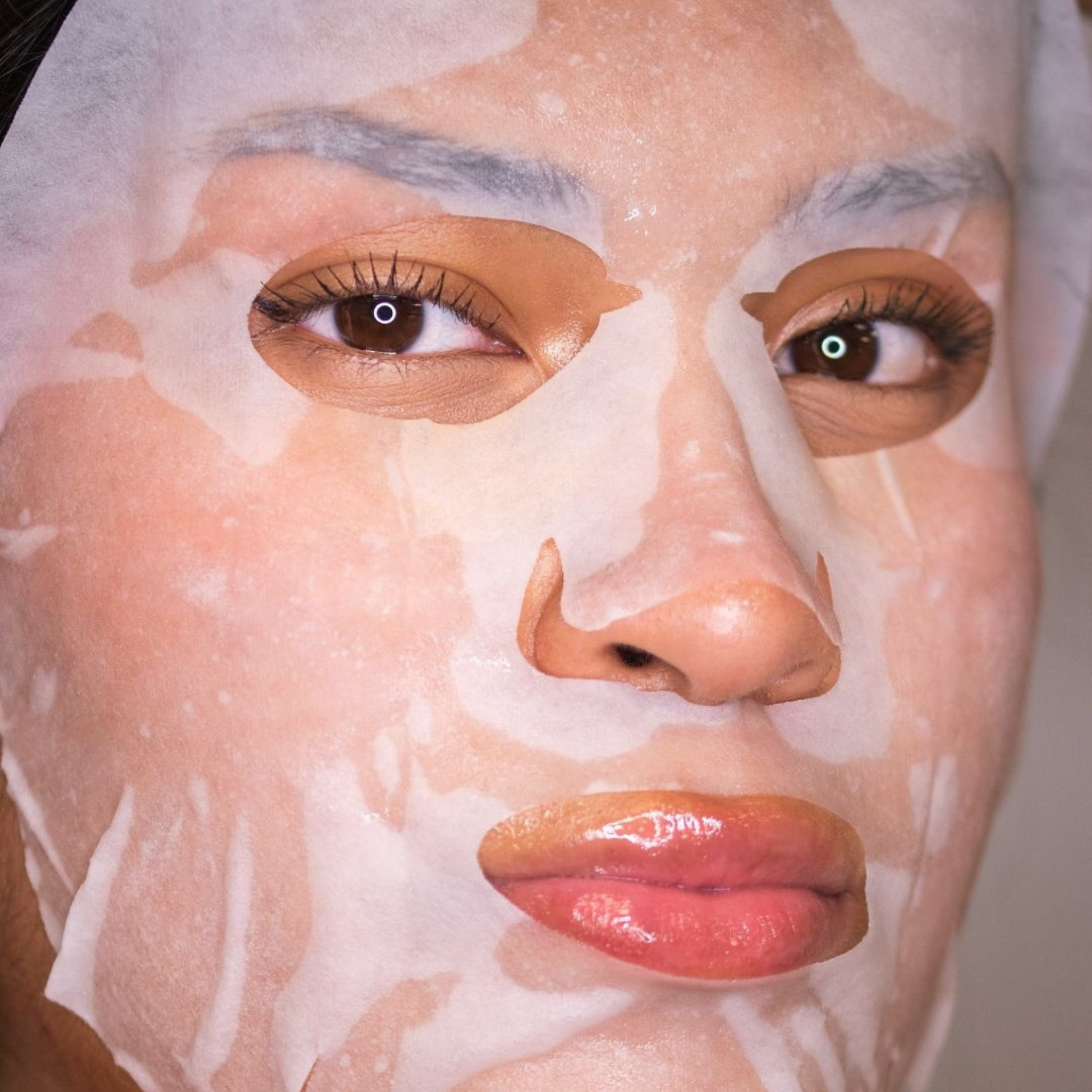 Close-up of a person's face with a white facial mask applied