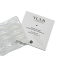 Yumi Lashes & Brows reusable silicone adhesive pads in a clear plastic tray next to their white product packaging box, labeled with size M.
