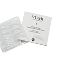 Yumi Lashes & Brows silicone adhesive pad packaging and a clear plastic tray of reusable adhesive pads on a white background. Labeled size M/L.