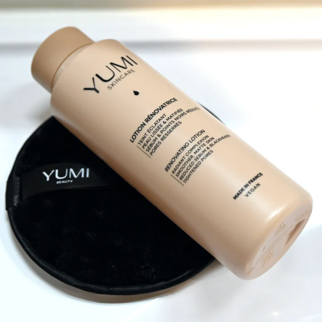 YUMI skincare lotion bottle on a white background