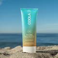 Coola Hydrating Sunscreen Lotion SPF30 with tropical coconut scent in a white bottle, showing the product label and logo.