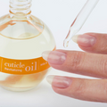 Cuccio Naturalé Roman Garden cuticle revitalizing oil applied on a hand, showcasing nourishing cuticle cream and oil for healthy nails.