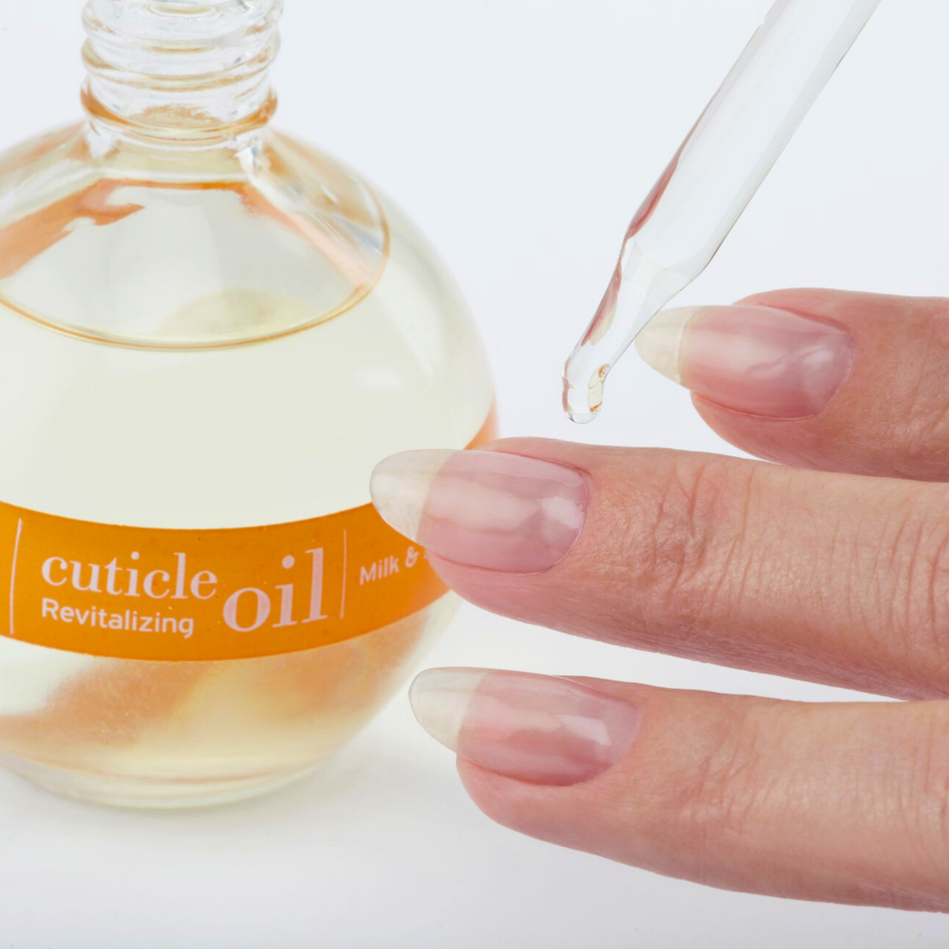 Cuccio Naturalé Roman Garden cuticle revitalizing oil applied on a hand, showcasing nourishing cuticle cream and oil for healthy nails.