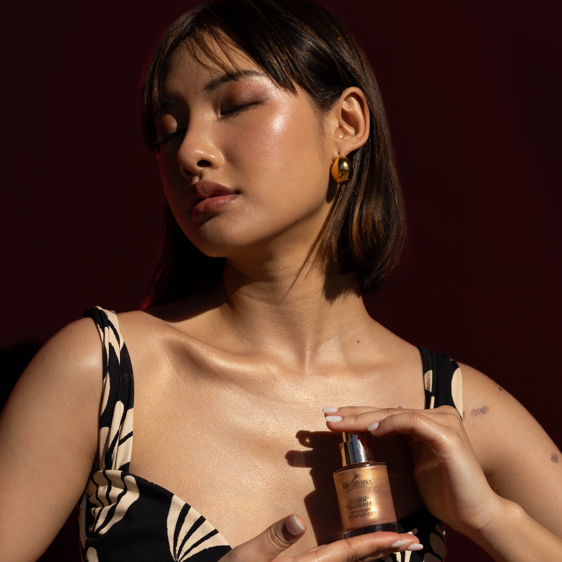 Eco by Sonya Driver Golden Illuminiser skincare serum in a sleek bottle with a golden glow, designed to enhance skin radiance.