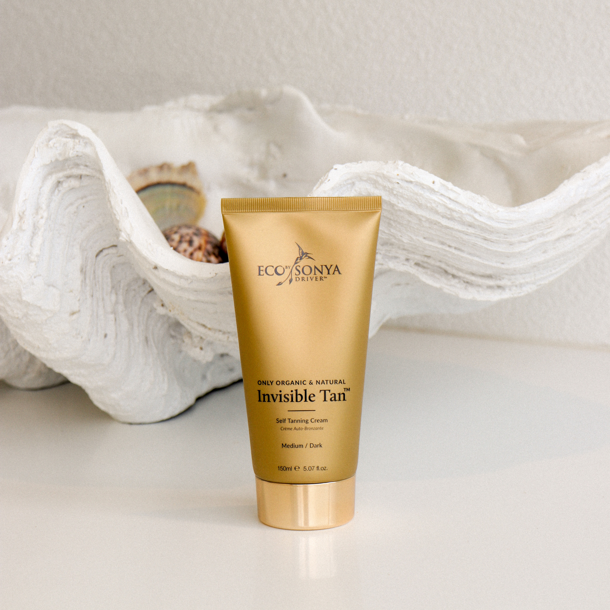 Eco By Sonya Driver invisible self-tanner in a sleek bottle, showing a smooth, natural glow applied to skin.