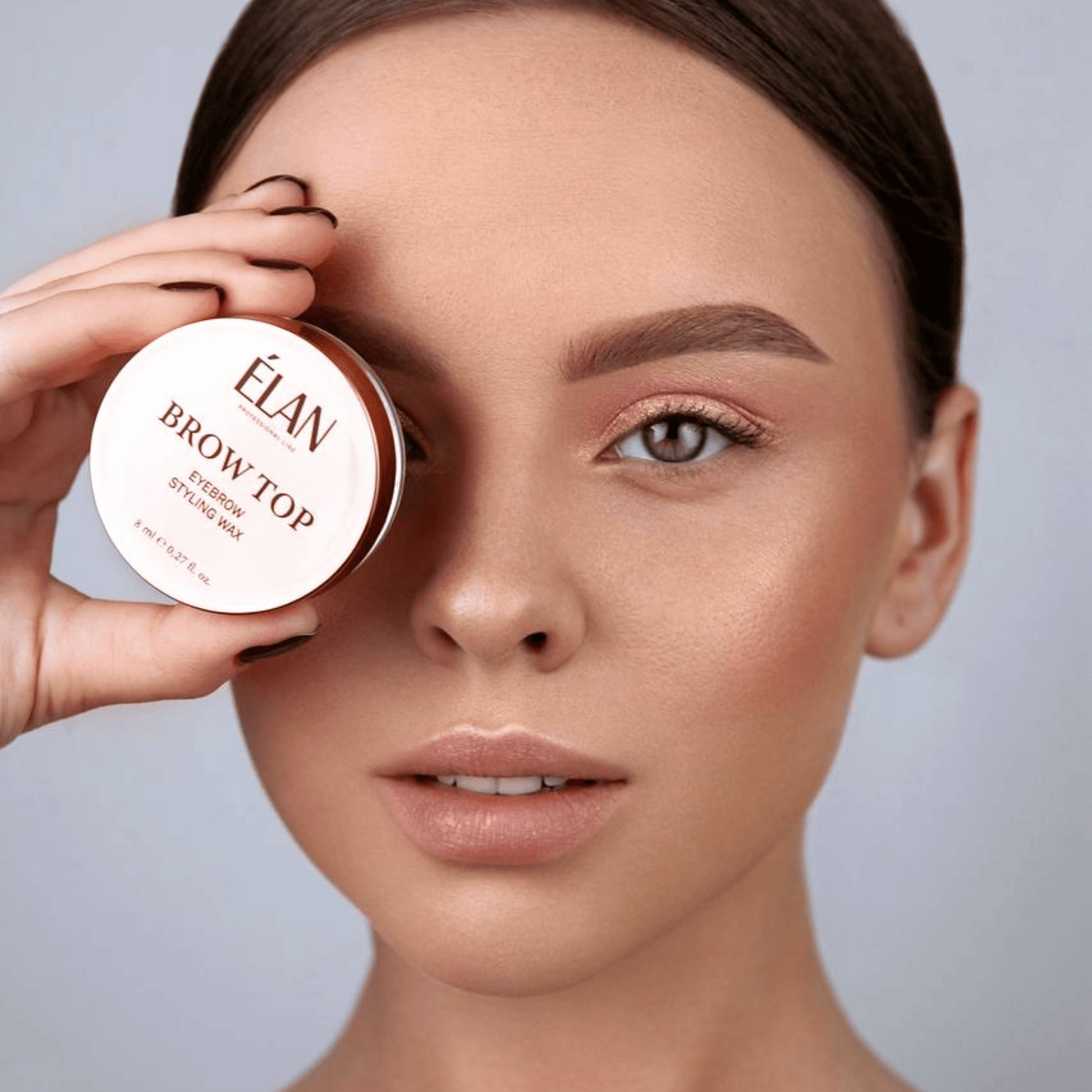 Élan Brow Top eyebrow styling wax in a compact container, designed for shaping and maintaining eyebrows.