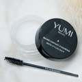 Yumi Brows Brow Styling Balm in a compact container, featuring brush applicator for shaping and defining eyebrows.