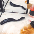 Yumi Brows Folding Eyebrow Comb from Yumi Lashes, showing the compact brow grooming tool with fine teeth for shaping and detangling.
