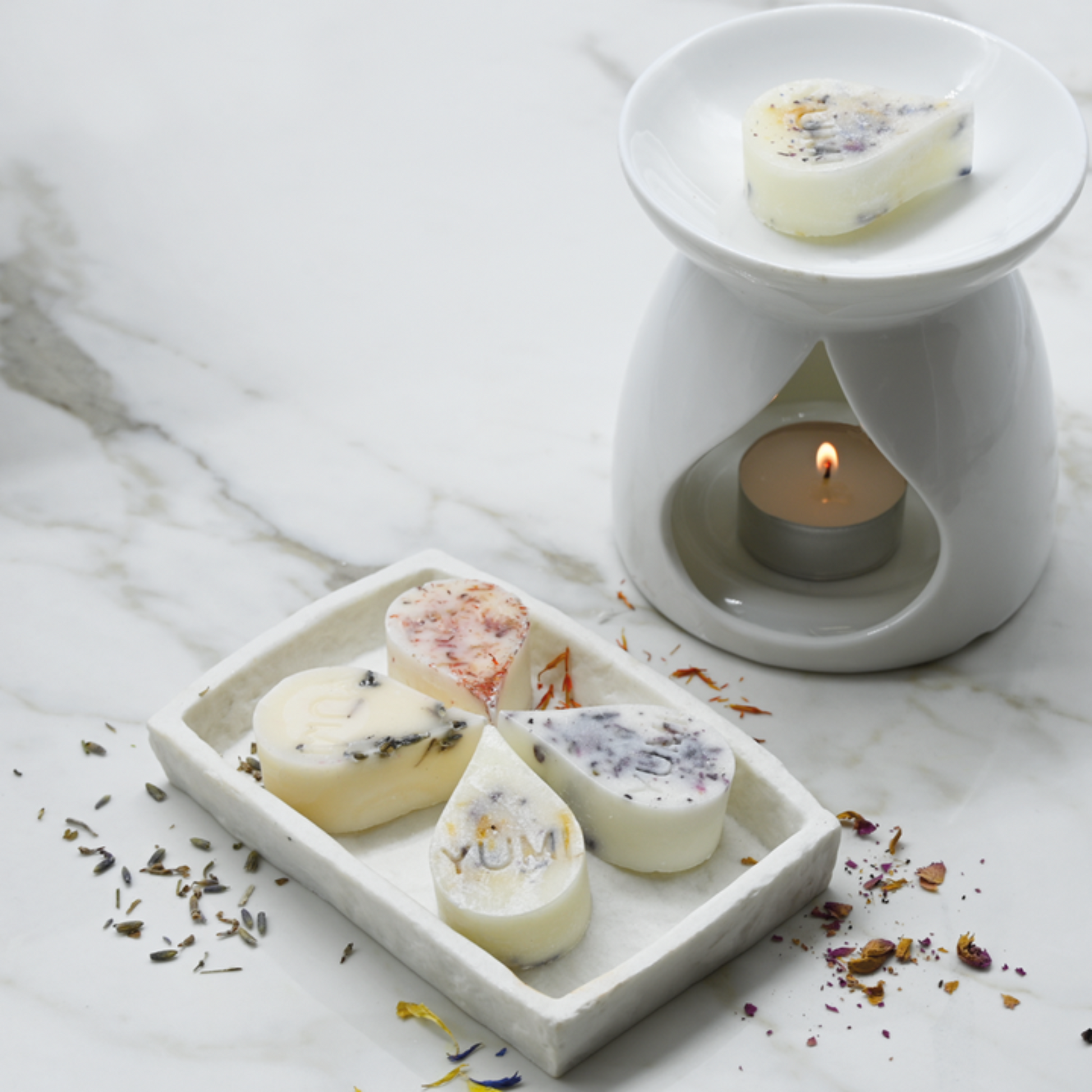 Yumi Beauty ceramic candle burner with a white fondant design, shown with a set of 16 candles for aromatherapy and home decor.