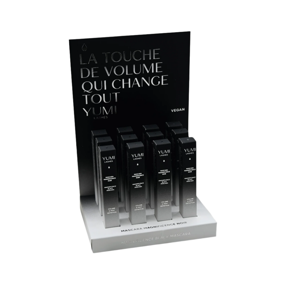 Display of Yumi Beauty Yumi Lashes Magnificence Black Mascara with multiple mascara tubes on a clear stand.