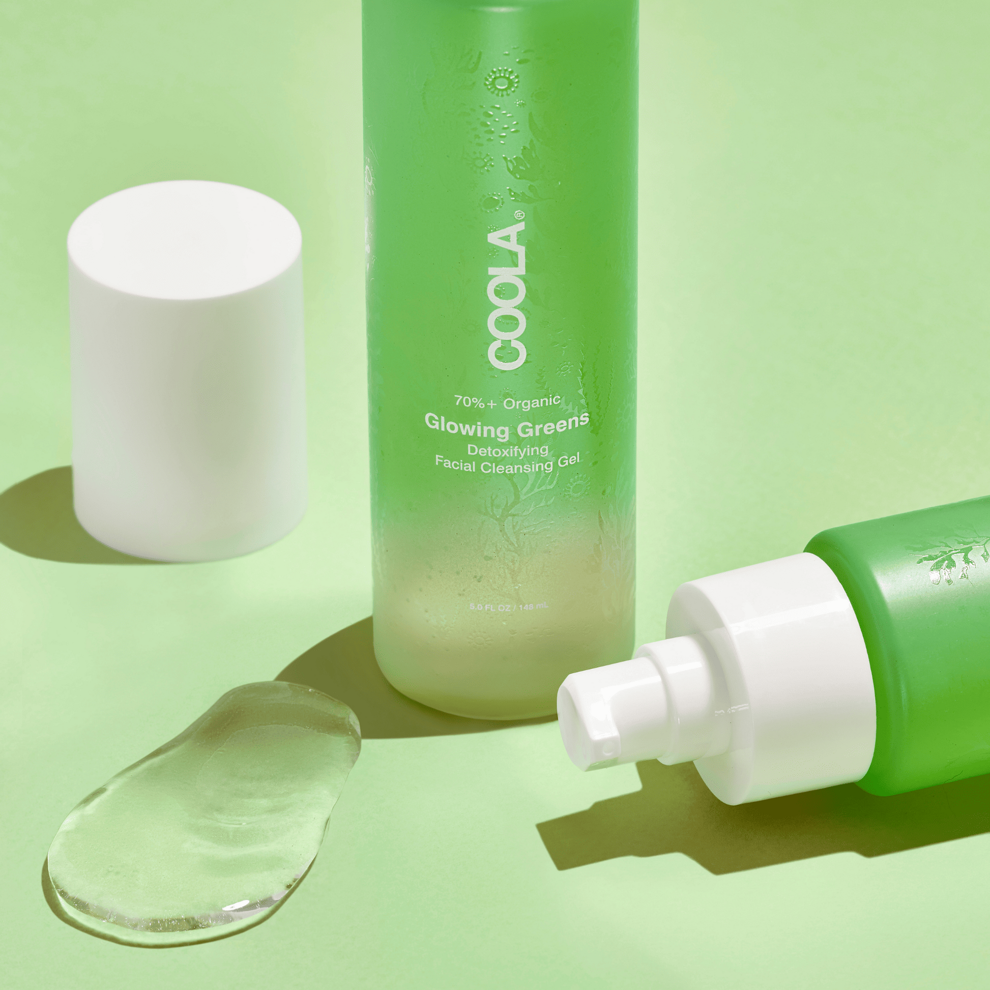Coola Glowing Greens Detoxifying Facial Cleansing Gel from Coola Suncare, showing the gel in a clear pump bottle with green accents.