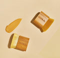 Coola Organic Sunless Tan Kabuki Body Brush for self-tanning, with soft bristles and ergonomic handle, used for applying self-tanner evenly.