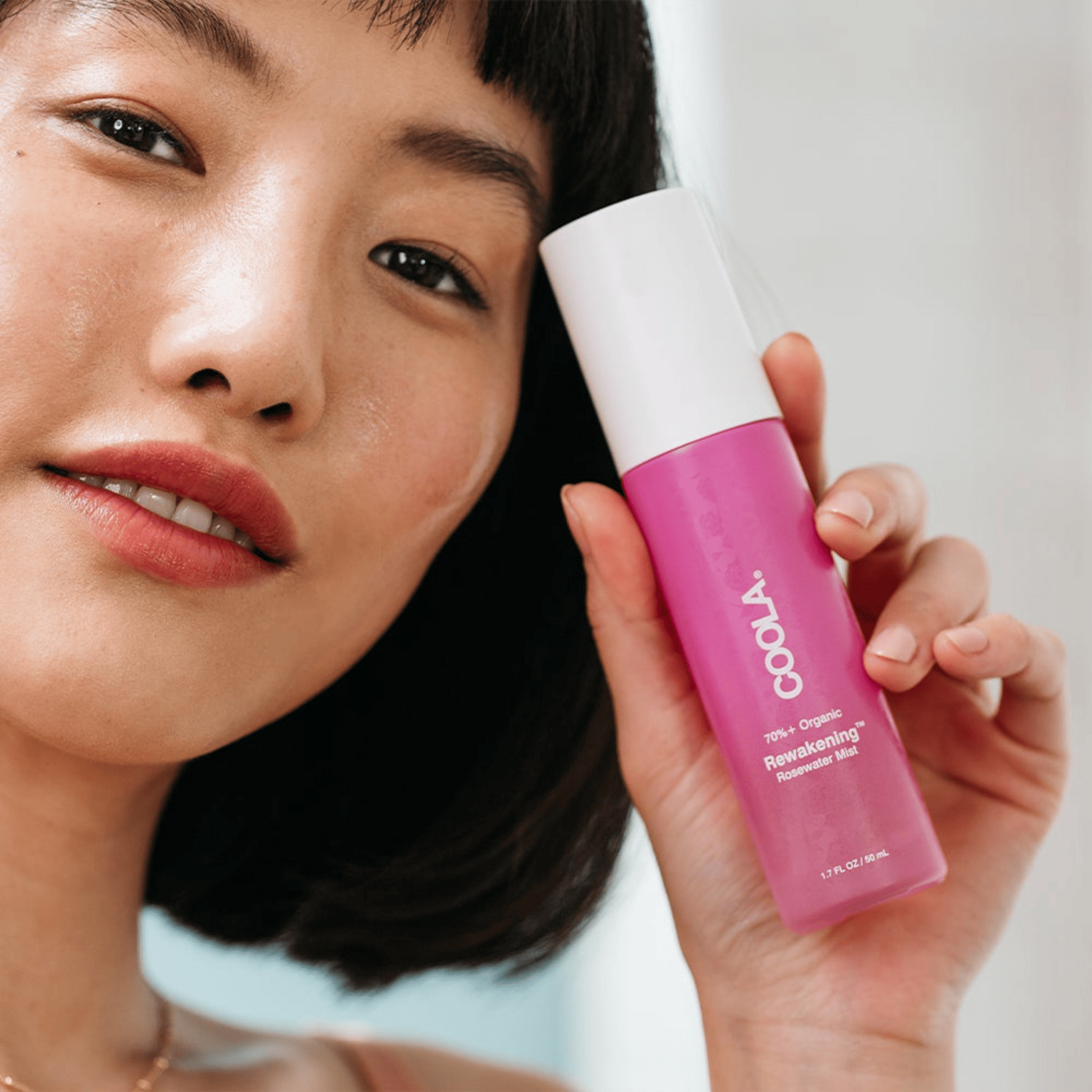 Coola Reawakening Rosewater Mist face spray in a clear bottle with a spray nozzle, designed to refresh and hydrate skin.