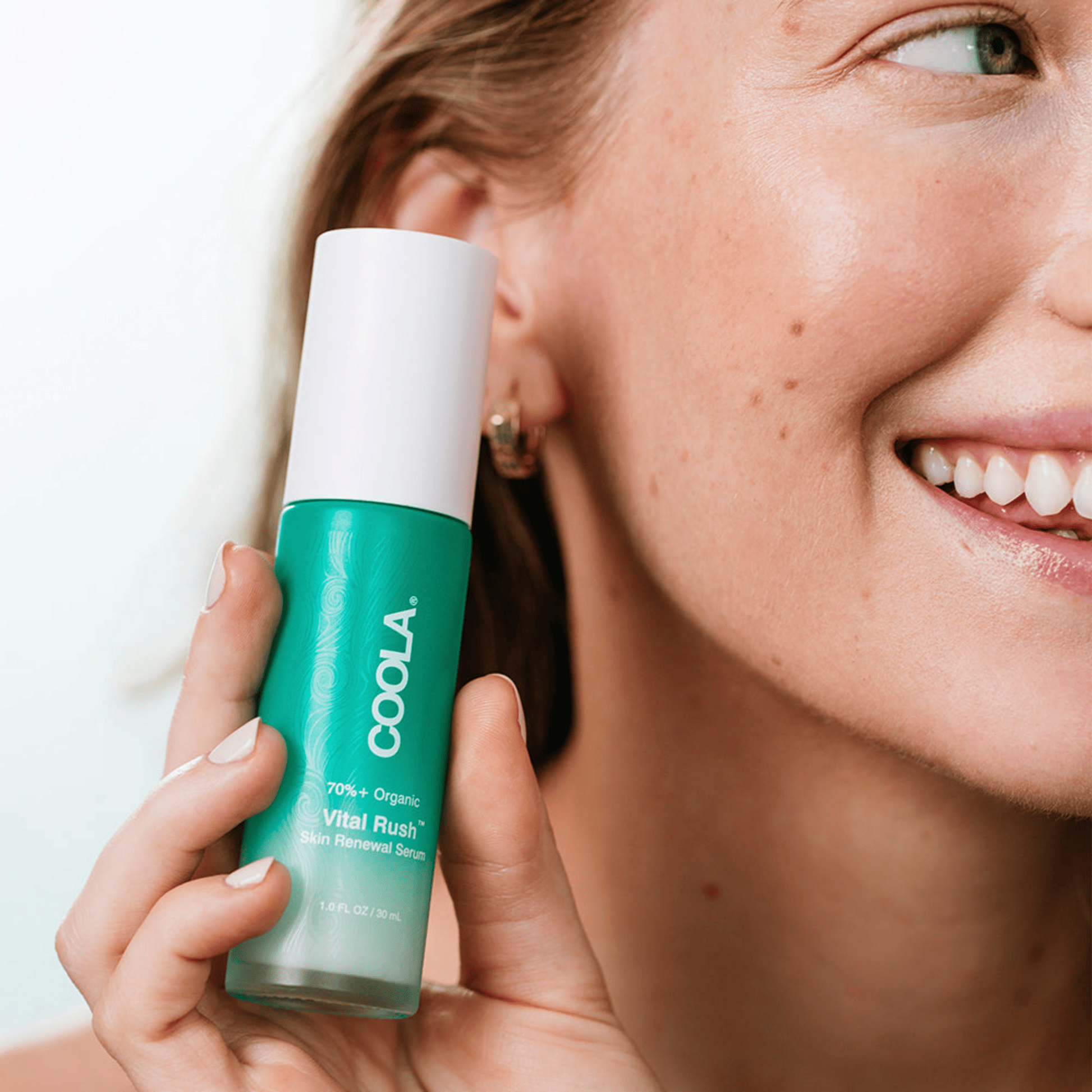 Coola Vital Rush Skin Renewal Serum in a clear glass bottle with dropper, showcasing vibrant orange packaging for skincare.