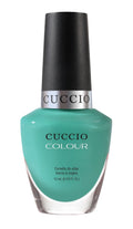 Close-up of Cuccio Colour Front Row nail polishes in various shades, displayed in a sleek, modern collection.