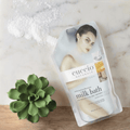 Creamy Cuccio Naturalé Milk Bath in a glass jar with a scoop, designed for relaxing bath and body skincare.