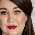 Gokos LipColor in Splendid Fuchsia, vibrant lipstick tube with open cap showing bright pink shade, makeup product on a white background.
