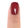 Zoya Yvonne nail polish bottle with the polish swatched on a nail, showcasing a vibrant, glossy finish in a close-up view.