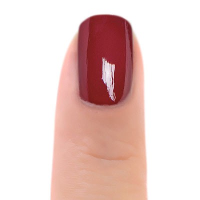 Zoya Yvonne nail polish bottle with the polish swatched on a nail, showcasing a vibrant, glossy finish in a close-up view.
